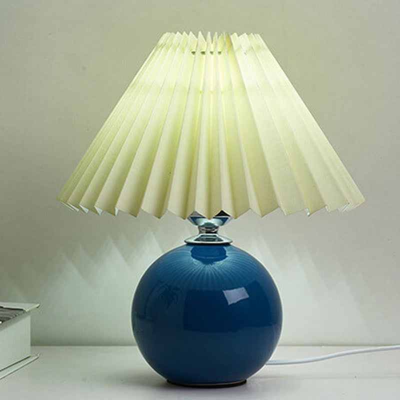 Lampa stołowa z ceramiczną podstawą i plisowanym abażurem