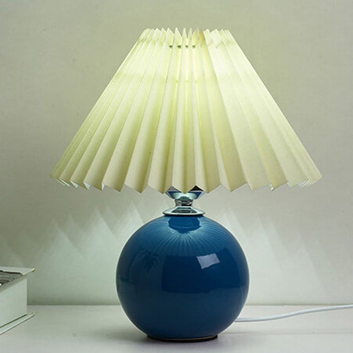 Lampa stołowa z ceramiczną podstawą i plisowanym abażurem