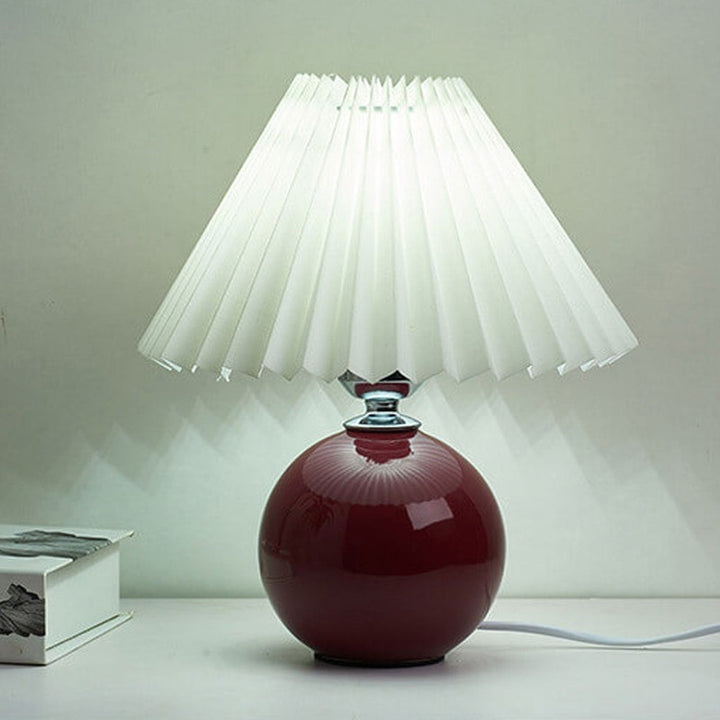 Lampa stołowa z ceramiczną podstawą i plisowanym abażurem