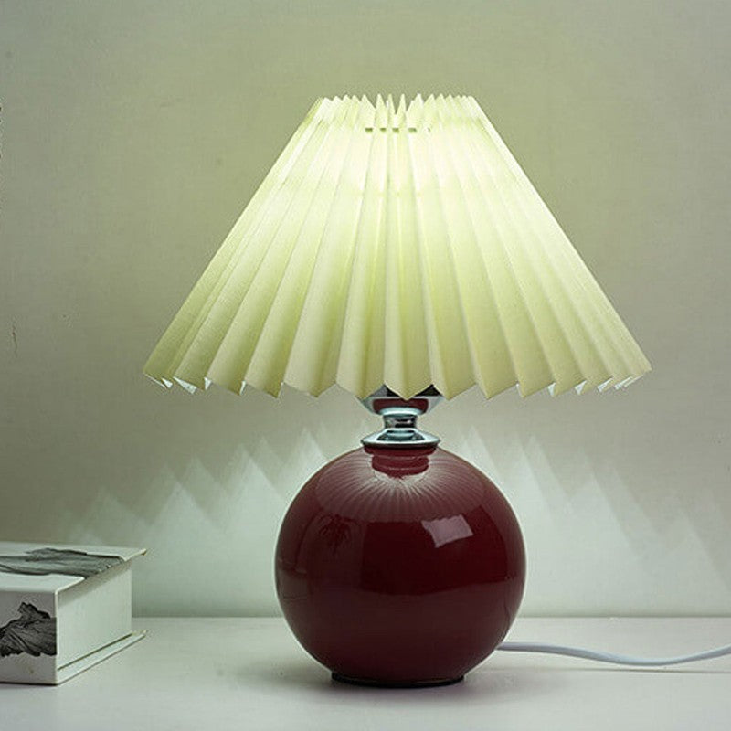 Lampa stołowa z ceramiczną podstawą i plisowanym abażurem