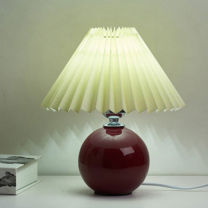 Lampa stołowa z ceramiczną podstawą i plisowanym abażurem