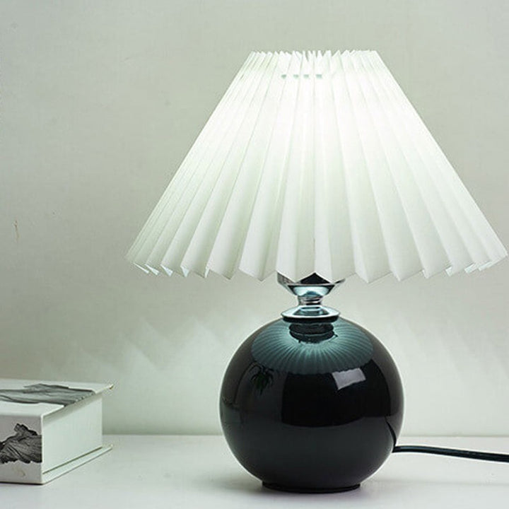 Lampa stołowa z ceramiczną podstawą i plisowanym abażurem