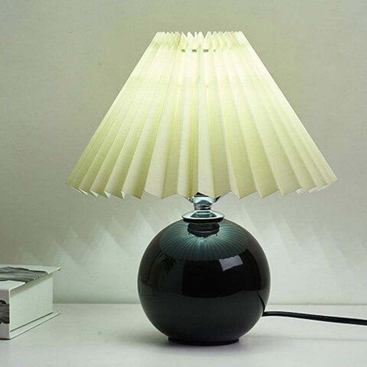 Lampa stołowa z ceramiczną podstawą i plisowanym abażurem
