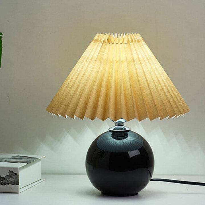 Lampa stołowa z ceramiczną podstawą i plisowanym abażurem