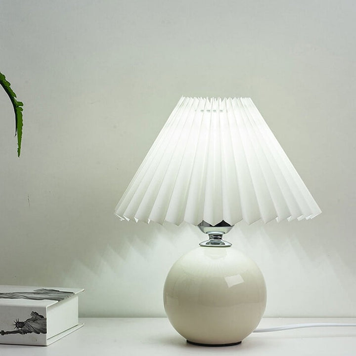 Lampa stołowa z ceramiczną podstawą i plisowanym abażurem