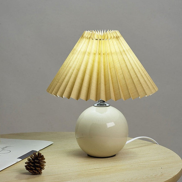 Lampa stołowa z ceramiczną podstawą i plisowanym abażurem