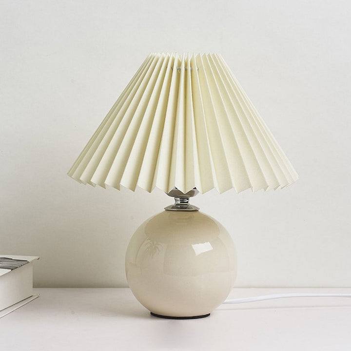 Lampa stołowa z ceramiczną podstawą i plisowanym abażurem