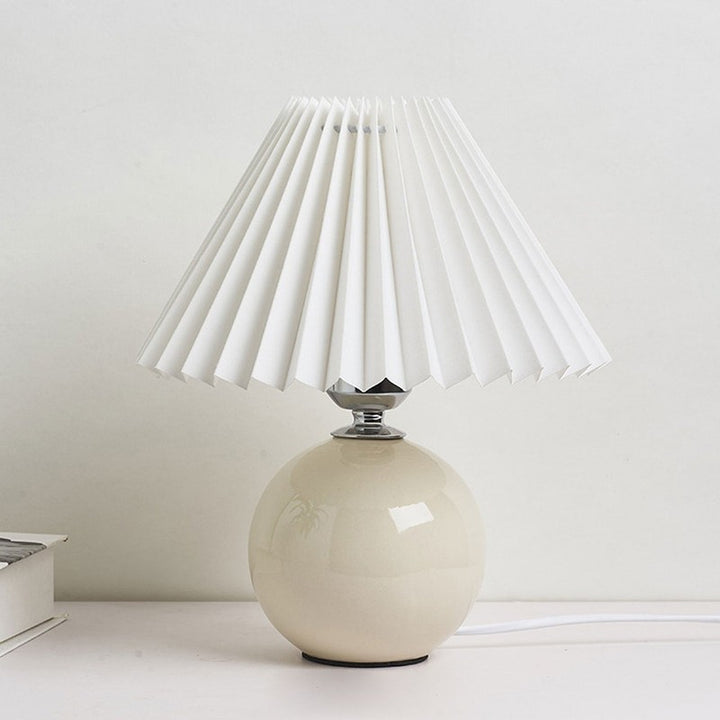 Lampa stołowa z ceramiczną podstawą i plisowanym abażurem