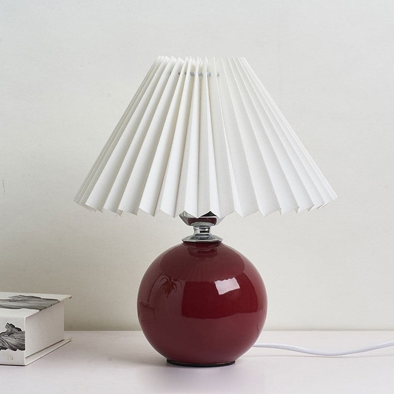 Lampa stołowa z ceramiczną podstawą i plisowanym abażurem