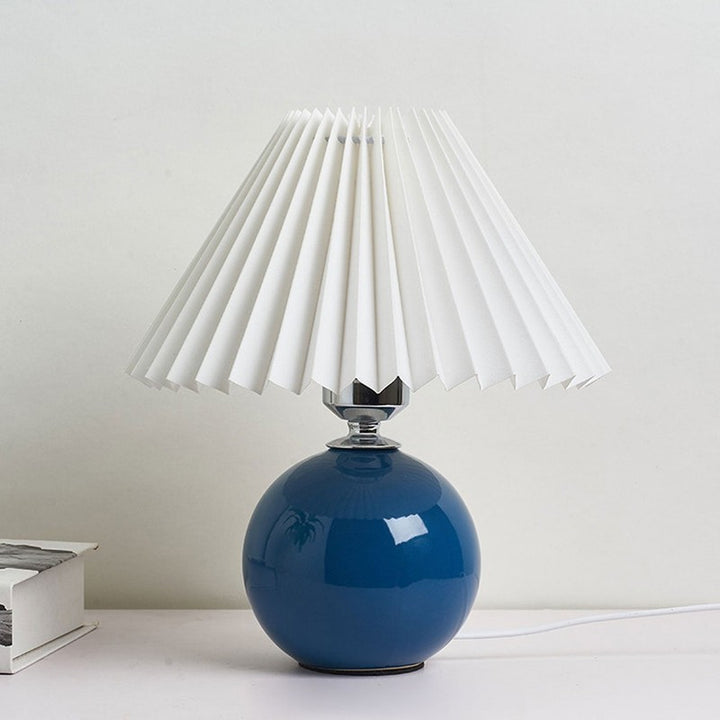 Lampa stołowa z ceramiczną podstawą i plisowanym abażurem