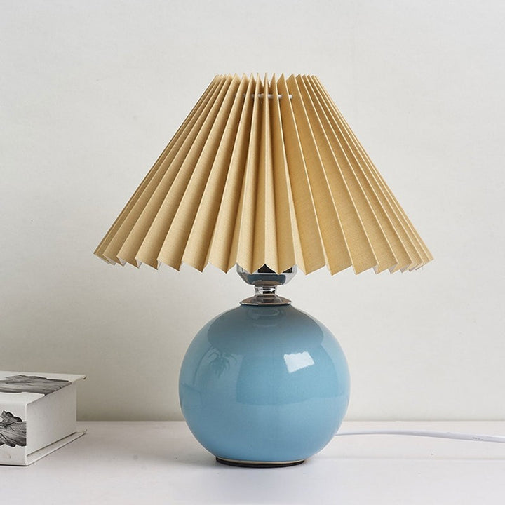 Lampa stołowa z ceramiczną podstawą i plisowanym abażurem
