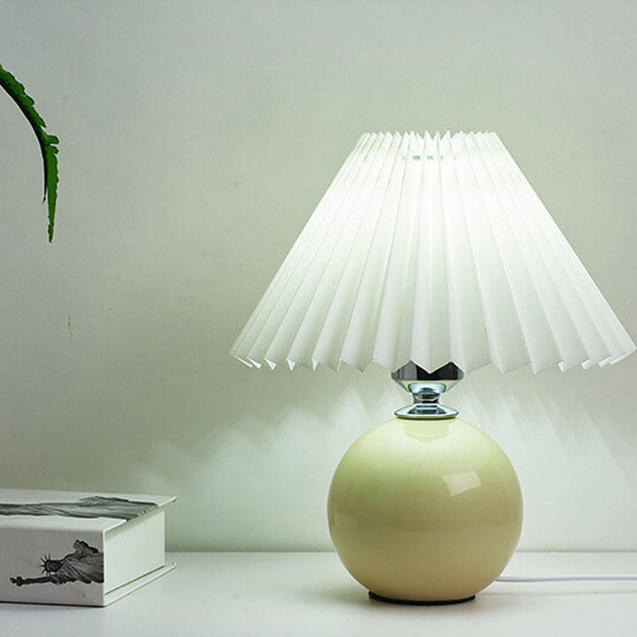 Lampa stołowa z ceramiczną podstawą i plisowanym abażurem