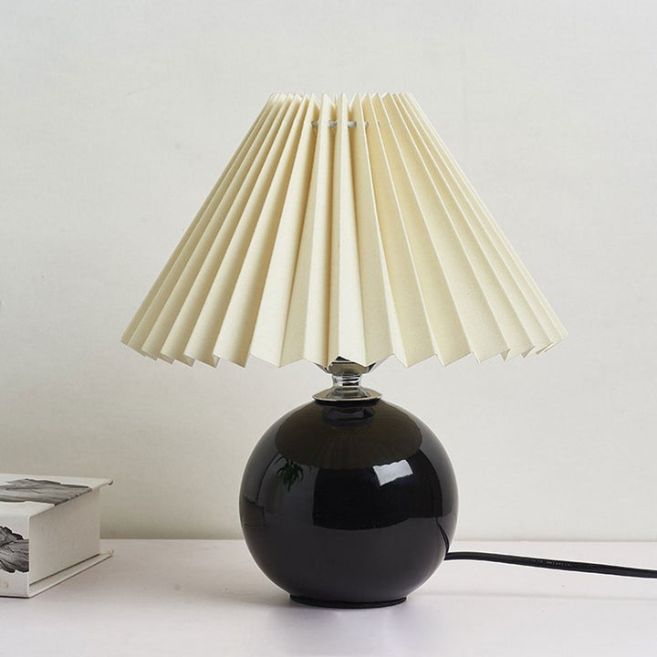 Lampa stołowa z ceramiczną podstawą i plisowanym abażurem