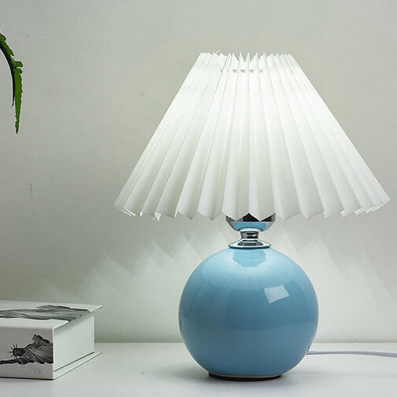 Lampa stołowa z ceramiczną podstawą i plisowanym abażurem