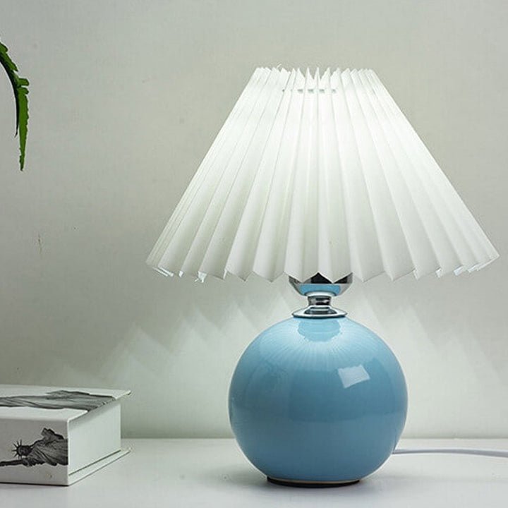 Lampa stołowa z ceramiczną podstawą i plisowanym abażurem